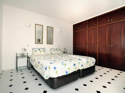 a bedroom with a large bed and wooden cabinets at VIVENDA JOHANNA in Lagos