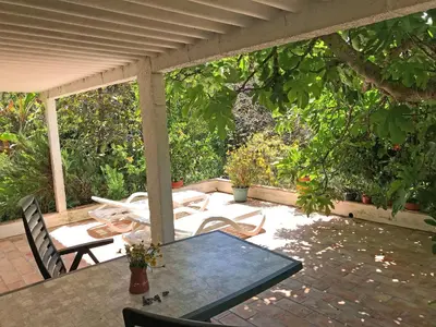a patio with a table and chairs under a pergola at VIVENDA JOHANNA in Lagos