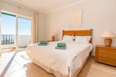 a bedroom with a large bed with a view of the ocean at Luz Top Views in Lagos