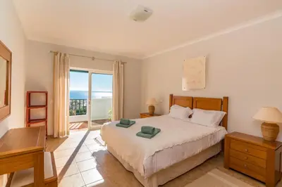 a bedroom with a bed with a view of the ocean at Luz Top Views in Lagos