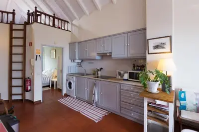a kitchen with white cabinets and a staircase in a room at OLD TOWN PENTHOUSE - Barreirinha in Funchal