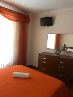 a bedroom with a bed and a dresser and a television at Andrade Blue in Caniço