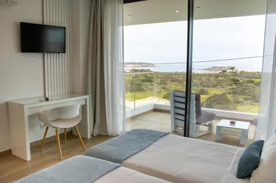 a bedroom with a bed and a large window at Sunrise Villa in Sagres