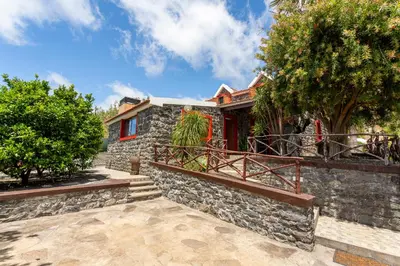 a house with a stone wall and a balcony at Refúgio do Lourinho in Funchal