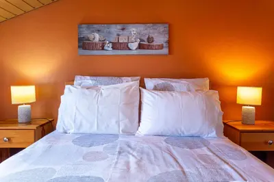a bedroom with a bed with white pillows and two lamps at Refúgio do Lourinho in Funchal