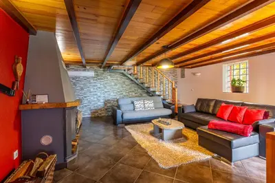 a living room with a couch and a stone wall at Refúgio do Lourinho in Funchal