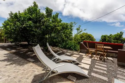 a group of white chairs and a table and bench at Refúgio do Lourinho in Funchal