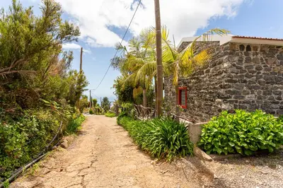 a dirt road next to a stone building at Refúgio do Lourinho in Funchal