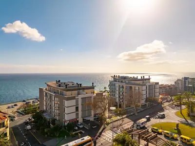 a building with a clock tower in the middle of a city at Two Bedroom Apartment with Balcony and Gorgeous view over the Atlantic in Funchal