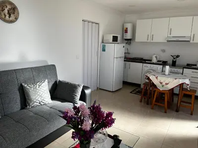 a living room with a couch and a table with flowers at SLICE OF PONTA DO SOL- GROUND FLOOR- SEA VIEW in Ponta do Sol