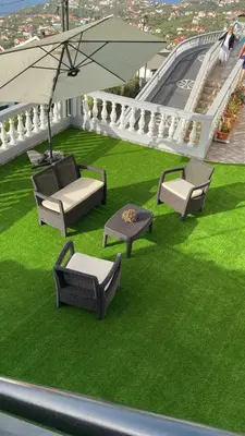 a group of chairs and an umbrella on a balcony at SLICE OF PONTA DO SOL- GROUND FLOOR- SEA VIEW in Ponta do Sol