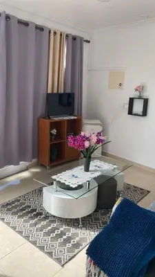 a living room with a coffee table and flowers on a rug at SLICE OF PONTA DO SOL- GROUND FLOOR- SEA VIEW in Ponta do Sol