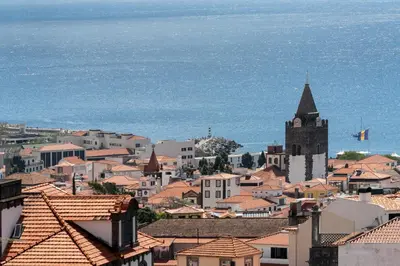 a white living room with a couch and a kitchen at Calçada do Pico I by An Island Apart in Funchal