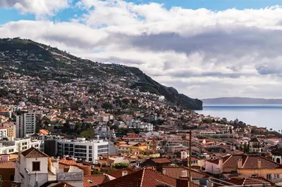 a patio with chairs and a table on a balcony at Calçada do Pico I by An Island Apart in Funchal