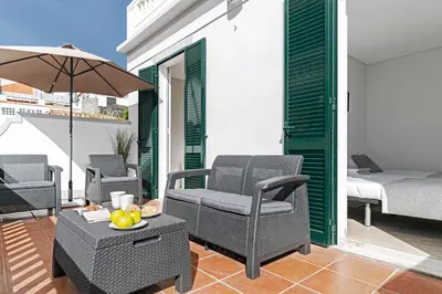 a patio with chairs and a table and a bed at Calçada do Pico I by An Island Apart in Funchal