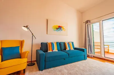 a living room with a blue couch and a yellow chair at FLH Funchal Ocean View with Pool in Funchal