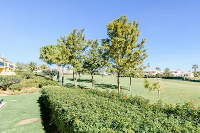 a row of trees in a park with a hedge at Boavista Golf Resort- Fairviews Villa in Lagos