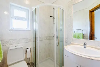 a bathroom with a shower and a toilet and a sink at Boavista Golf Resort- Fairviews Villa in Lagos