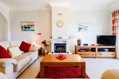 a living room with a couch and a fireplace at Boavista Golf Resort- Fairviews Villa in Lagos