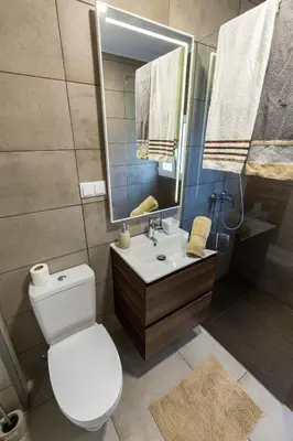 a bathroom with a toilet and a sink and a mirror at Sea Breeze II in Caniço