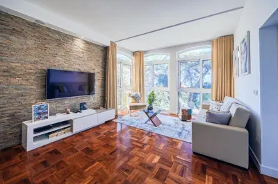 a living room with a television on a brick wall at Sea Breeze II in Caniço