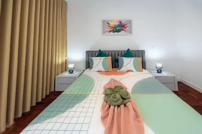 a bedroom with a large bed with curtains at Sea Breeze II in Caniço