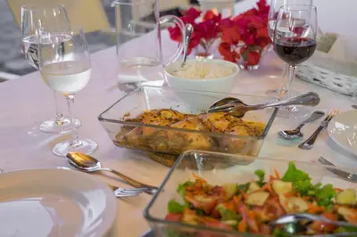 a table topped with dishes of food and glasses of wine at Casa das Proteas in São Jorge