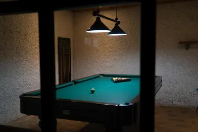 a room with a pool table and two lights at Casa das Proteas in São Jorge