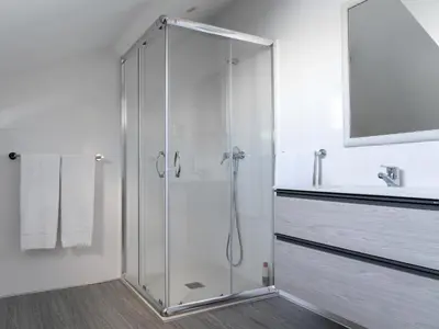 a shower with a glass door in a bathroom at Casa das Proteas in São Jorge