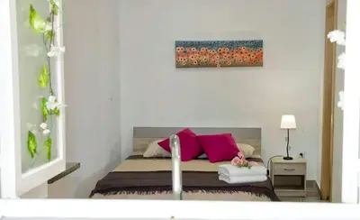 a bedroom with a bed with pink pillows at Tabua Village Madeira in Ribeira Brava