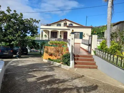 a white house with a staircase in front of it at Tabua Village Madeira in Ribeira Brava