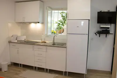 a white kitchen with a sink and a refrigerator at Tabua Village Madeira in Ribeira Brava