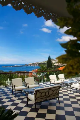 a group of chairs sitting on a checkered floor at Hotel Quinta Bela S Tiago in Funchal