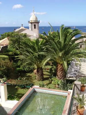 a view of a resort with palm trees and a swimming pool at Hotel Quinta Bela S Tiago in Funchal