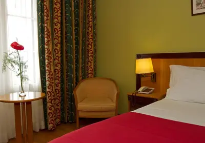 a bedroom with a bed and a chair and a window at Hotel Quinta Bela S Tiago in Funchal