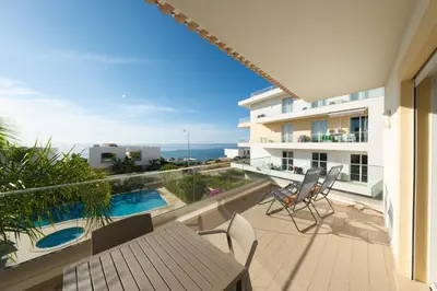 a balcony with a view of the ocean from a building at Porto de Mós 72 by Destination Algarve in Lagos