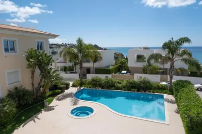 a villa with a swimming pool in front of a house at Porto de Mós 72 by Destination Algarve in Lagos