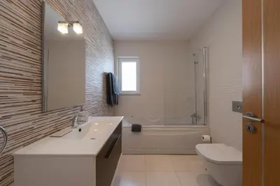 a bathroom with a sink and a toilet and a tub at Porto de Mós 72 by Destination Algarve in Lagos