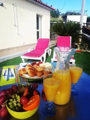 a table with a plate of food and two glasses of orange juice at Madeira House in Calheta