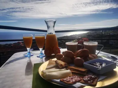 a plate of food on a table with glasses of orange juice at Madeira House in Calheta
