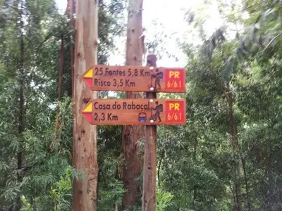 a sign on a pole with street signs on it at Madeira House in Calheta