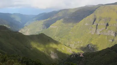 a view of a mountain valley with green hills at Madeira House in Calheta