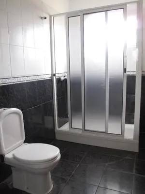 a bathroom with a toilet and a glass shower at Madeira House in Calheta