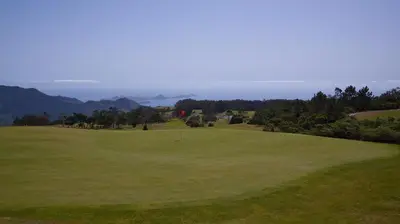 a view of a golf course with a green at Quinta das Colmeias in Santo da Serra