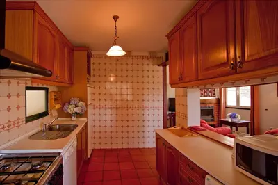a kitchen with wooden cabinets and a sink at Quinta das Colmeias in Santo da Serra