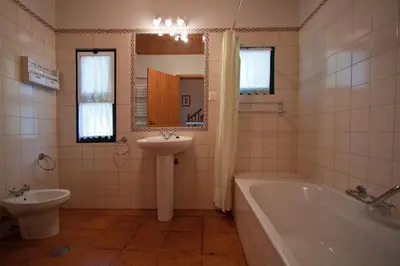 a bathroom with a tub and a sink and a toilet at Quinta das Colmeias in Santo da Serra