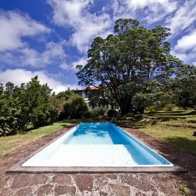 a swimming pool in the yard of a house at Quinta das Colmeias in Santo da Serra