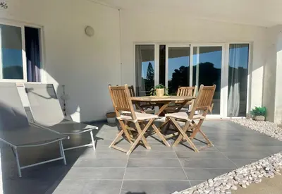a black chair with a blanket sitting next to a plant at Casa da praia in Aljezur