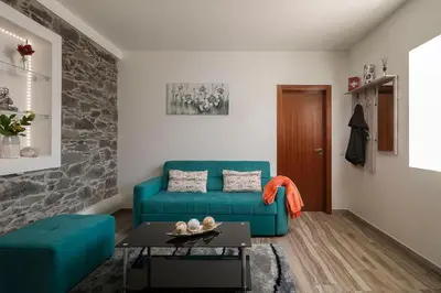 a living room with a blue couch and a table at Casa Tiana Madeira in Ponta do Sol