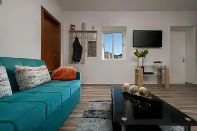 a living room with a blue couch and a tv at Casa Tiana Madeira in Ponta do Sol